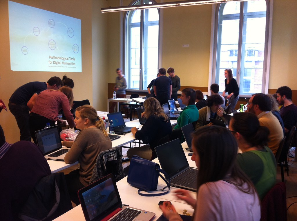 Groupe d'étudiants rassemeblés dans uns salle de formation, au fond de la salle une projection d'image sur le mur